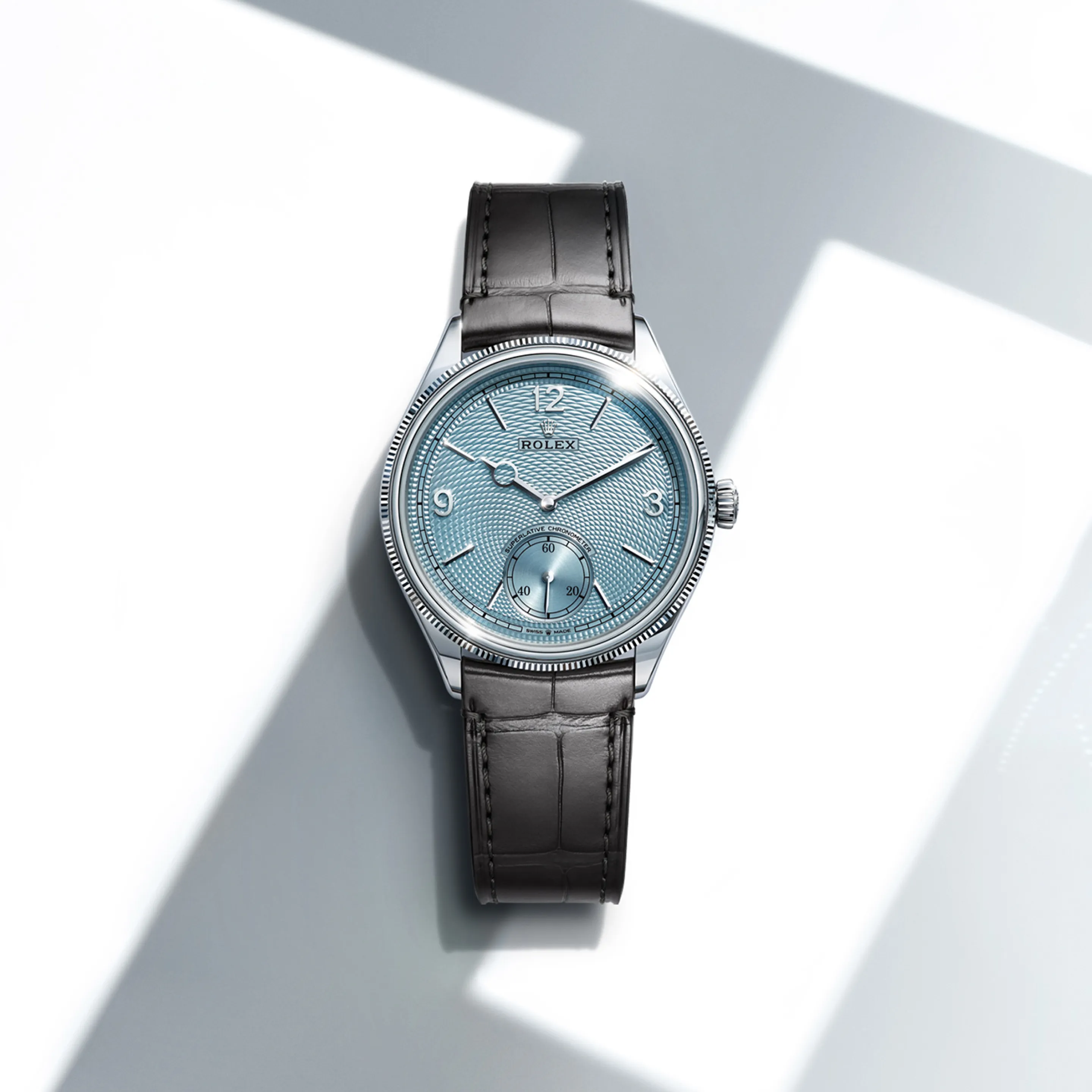rolex 1908    - Il quadrante blu ghiaccio presenta un motivo a grana di riso. Il disegno che ne risulta è ottenuto mediante guillochage e ricorda un rosone, con i motivi geometrici tridimensionali che si ripetono fino a ricoprire l’intera superficie del quadrante, partendo dal contatore dei piccoli secondi a ore 6. Sul bordo del quadrante, la minuteria è impreziosita da entrambi i lati da un sottile filetto con superficie in rilievo e motivo a cremagliera, anch’esso guilloché. Presentando un quadrante decorato con la tecnica del guillochage, dove il motivo è tagliato su una superficie con un bulino, Rolex prosegue l’obbiettivo dichiarato della collezione Perpetual: rendere omaggio all’arte dell’orologeria classica arricchendola con i suoi know‑how e la sua creatività. Questo quadrante esclusivo esibisce gli stessi numeri arabi 3, 9 e 12, gli stessi indici sfaccettati e le stesse lancette che caratterizzano le versioni in oro 18 ct. 

Il raffinato colore del quadrante è disponibile unicamente per il Day‑Date, il Cosmograph Daytona, il Perpetual 1908 e il Land‑Dweller.