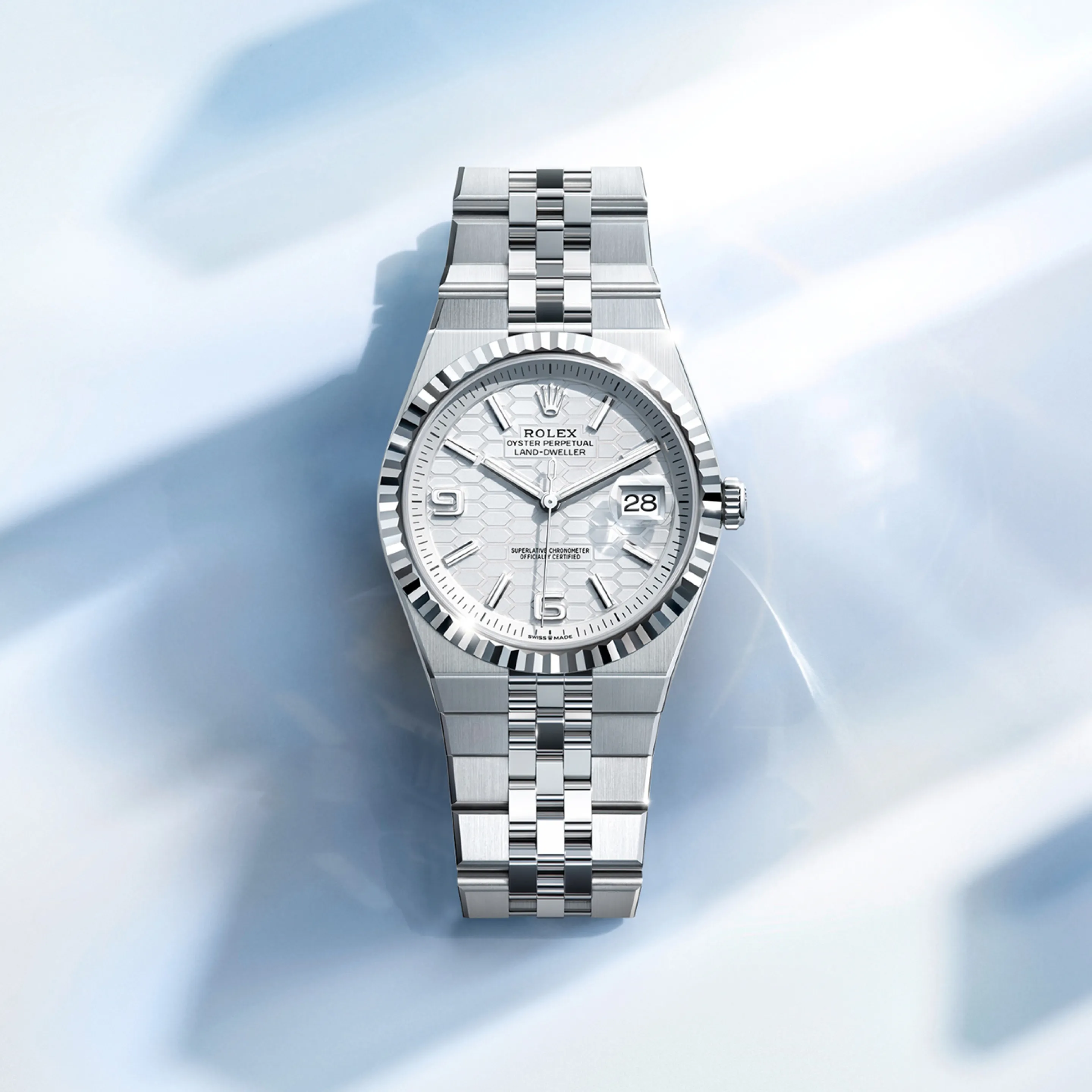 rolex Land-Dweller    - Questo quadrante blu ghiaccio, un colore riservato agli orologi realizzati in platino, è impreziosito dal motivo a nido d’ape con finitura soleil. Per realizzarlo, il Marchio ha fatto ricorso sia alle tecniche tradizionali, sia ai procedimenti di alta tecnologia, tutti perfettamente dominati in‑house. Il taglio degli alveoli e l’esecuzione delle striature all’interno delle scanalature che li separano richiedono l’intervento del laser a femtosecondi. Il quadrante presenta 10 diamanti taglio baguette incastonati a indicare le ore.