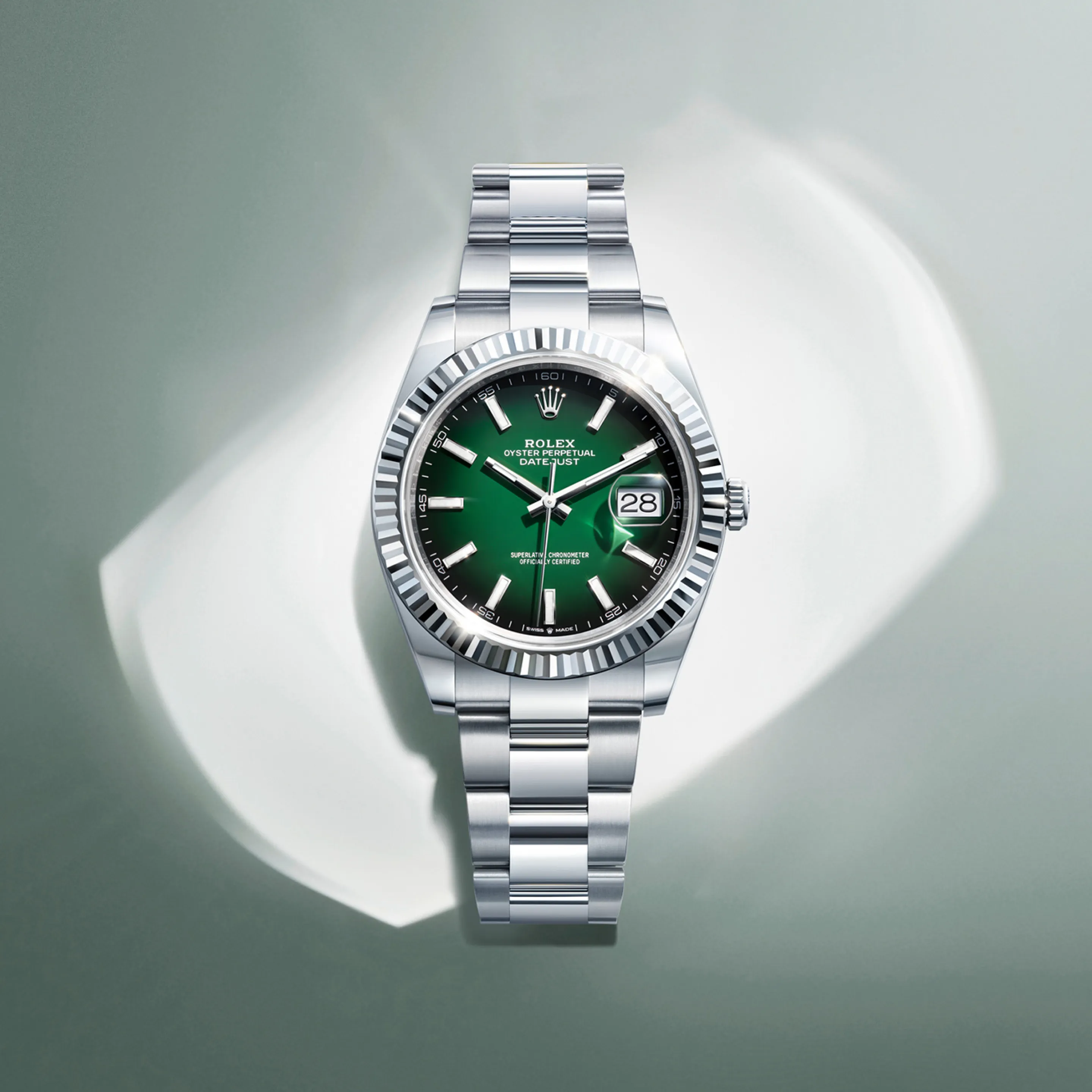 Rolex Datejust – The dial features Roman numerals VI and IX in 18 ct gold, set with 24 diamonds. The sunray finish creates delicate light reflections across many dials in the Oyster Perpetual collection. Achieving this effect involves expert brushing techniques that produce subtle grooves radiating from the center of the dial outwards. Light spreads evenly along each groove, creating a characteristic, subtle glow that shifts with the movement of the wrist. Once the sunray finish is complete, the dial color is applied using physical vapor deposition or electroplating. A fine layer of varnish gives the dial its final appearance.
